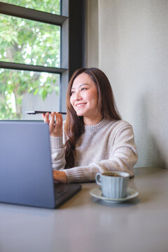 Vertical of a woman holding smart phone and using voice messaging, talking with ai assistant for Artificial intelligence concept while working on laptop