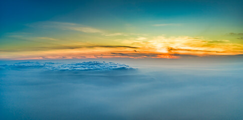 Fototapeta premium Magnificent sunrise above a vast sea of clouds, with golden sunlight streaming across the mist to create a dramatic and peaceful atmosphere