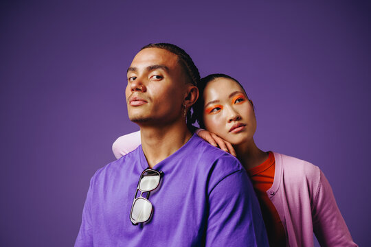 With connection and affection, friends lean together in a modern studio portrait