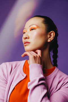 Confident Asian woman with bold makeup in studio portrait