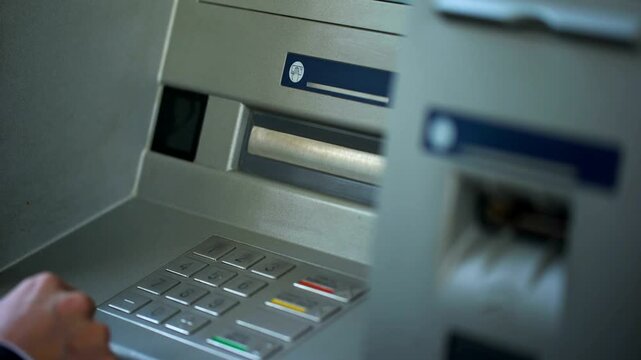 Man in suit finishing banking transaction and pressing cancel button on ATM machine to remove his debit card in 4K Ultra HD footage

