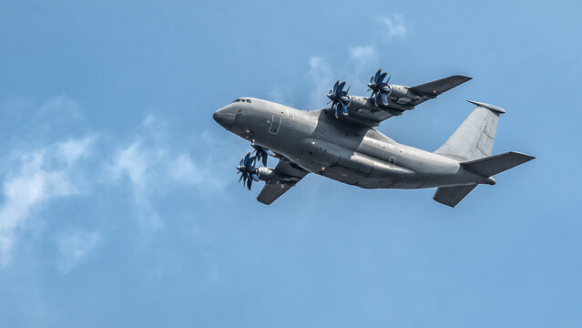 Four-engine military cargo plane flying high with empty space for text