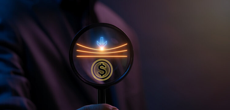 Close-up shot of hand holding magnifying glass to inspect glowing economic resilience icon. Dark neon lighting, economic resilience audit and financial stability inspection concept.