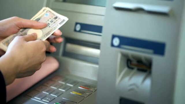 Female counting japanese yen withdrawn from ATM machine and putting cash in purse during tourism travel in 4K Ultra HD footage
