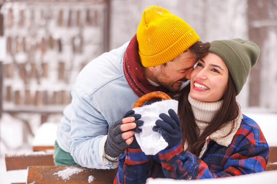 Couple taking a snack break while spending snowy winter day outdoors in nature