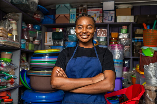 Smiling african woman entrepreneur standing confidently in her small shop, SME