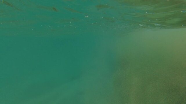 FPV view going in and out of water on a puerto rican beach during a sunny day.