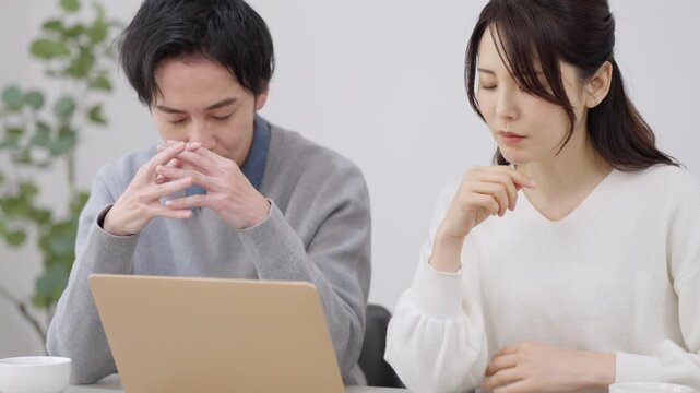 パソコンを見る夫婦・カップル