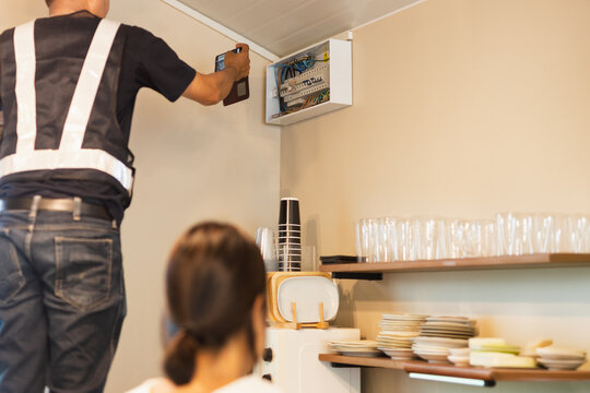 Electrician take photos electrical breaker panel with a smartphone during safety check.
