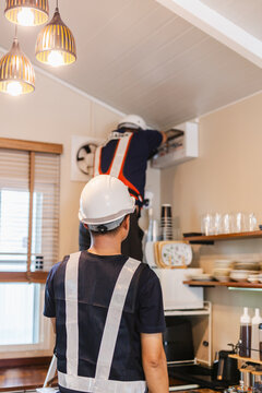 Electricians conducting a cafe electrical safety inspection breaker panel.