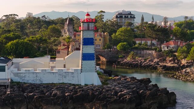 Santa Marta Lighthouse with the Museu Condes de Castro Guimar&atilde;es overlooking the Atlantic coastline in Cascais, Portugal, during golden hour.