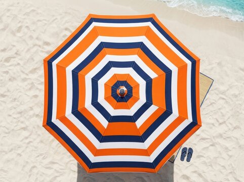 Top view of a colorful striped beach umbrella sitting on the sand on a sunny summer day at the ocean