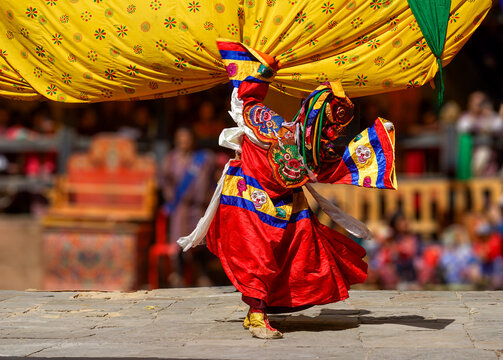 Bhutan, In the village of Bumthang, a monk in colorful costumes dance during the Jakar festival.
