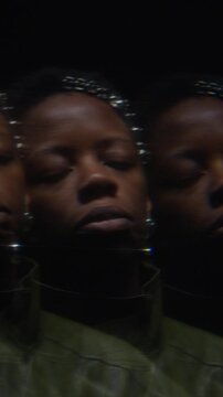 Portrait of young adult African American woman looking around with prism reflection effect. Creative footage is suitable for mental health or identity concepts, vertical