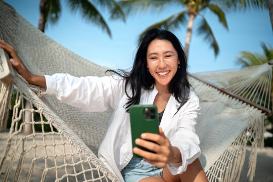 Content creator woman taking a selfie or streaming live from a scenic beach