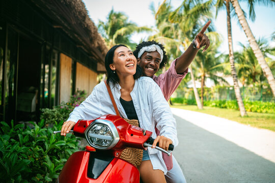 Young tourists renting a red scooter to explore a tropical island during their summer holiday trip
