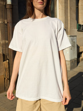 Woman wearing a plain white t-shirt and beige shorts outdoors