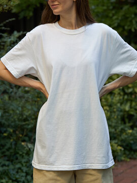Woman wearing a plain white t-shirt and beige shorts outdoors