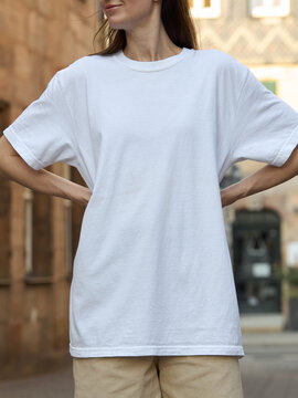 Woman wearing a plain white t-shirt and beige shorts outdoors