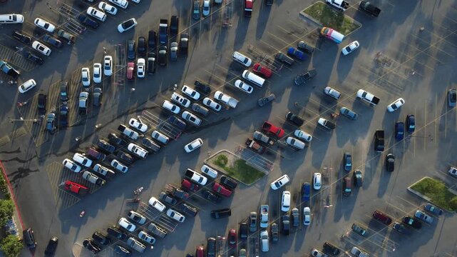 Angled parking rows border central driving paths in West Side District along Potranco Road during peak rush hour. Customers return carts amidst steady vehicle traffic, San Antonio, Texas
