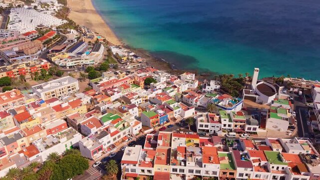 Ambient drone exploration of the Morro Jable town known for its beaches, like vast Playa del Matorral, with its Morro Jable Lighthouse. Drone POV of Fuertaventura Island.