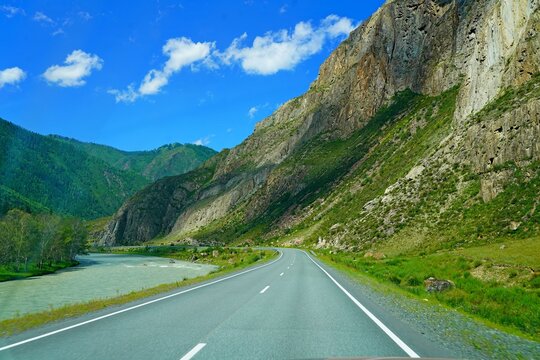 empty asphalt road among mountain forest, sunny day clear sky, summer landscape