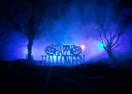 Halloween concept. Creepy silhouette in the dark corridor with pumpkin head. Toned light with fog on background.