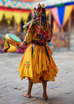 Bhutan, In the village of Bumthang,a monk in colorful costumes dances during the Jakar festival.
