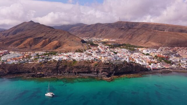 Ambient drone exploration of the Morro Jable town known for its beaches, like vast Playa del Matorral, with its Morro Jable Lighthouse. Drone POV of Fuertaventura Island.