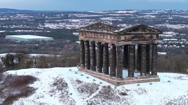 Aerial drone orbit shot around the snow-covered Penshaw Monument on Penshaw Hill, featuring Sunderland and Washington across the winter background.