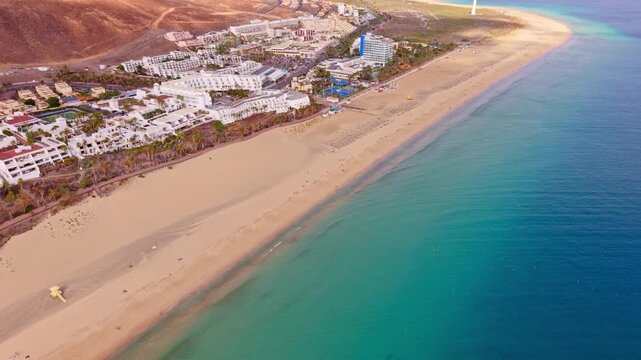 Ambient drone exploration of the Morro Jable town known for its beaches, like vast Playa del Matorral, with its Morro Jable Lighthouse. Drone POV of Fuertaventura Island. Lighthouse expedition.