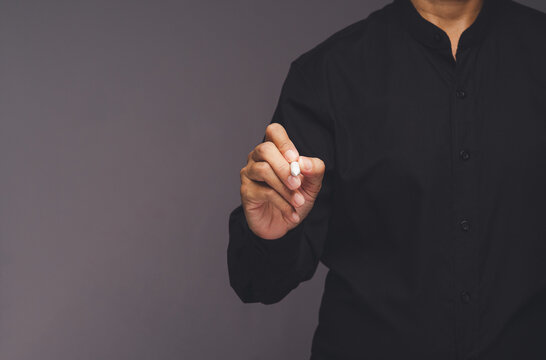 Person writing with stylus on gray background with copy space