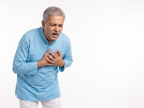 Senior Indian man holding chest in sudden cardiac pain isolated on white background with copy space for heart attack symptoms emergency healthcare cardiology awareness and senior wellness concepts