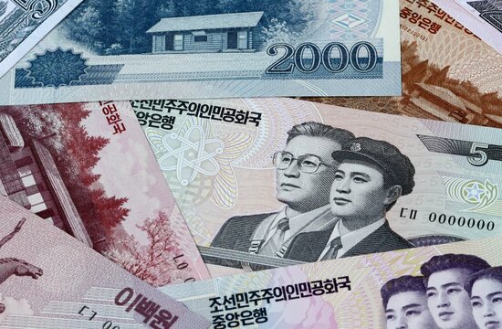 North Korean won money bills in pile on table. North Korea KPW currency cash close up