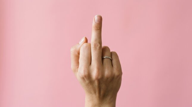 Hand Gesture with Middle Finger Raised Against Pink Background
