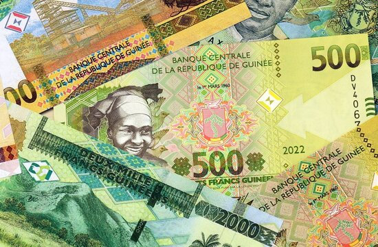 Guinean franc money bills in pile on table. Guinea GNF currency cash close up