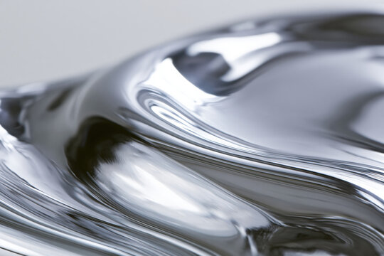 Abstract macro shot of flowing rippling liquid surface with smooth shiny texture and reflective silver color creating dynamic and fluid visual effect