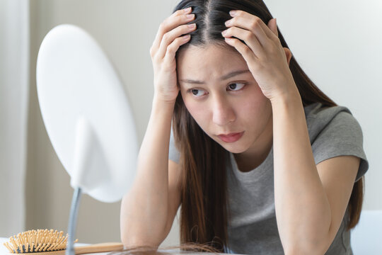 Young woman worrying about her thin hair and hair fall