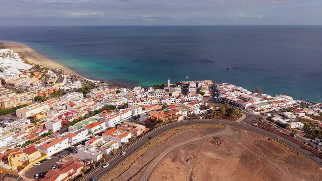 Ambient drone exploration of the Morro Jable town known for its beaches, like vast Playa del Matorral, with its Morro Jable Lighthouse. Drone POV of Fuertaventura Island.