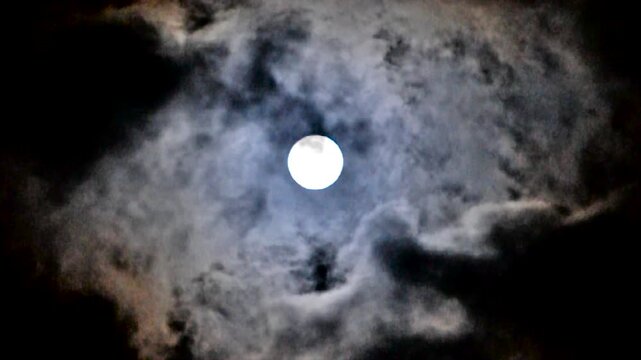 Halloween sinister sky, mysterious midnight sky with shining full moon and slowly floating clouds, night landscape