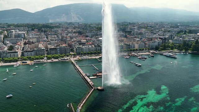 Cinematic aerial drone footage of Geneva showcasing the stunning shoreline of Lake Geneva, the modern city skyline, historic architecture, and surrounding Alpine scenery.