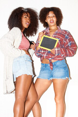 Obraz na płótnie Canvas Fashion, friends and women with board on a white background for news, information and announcement. Confidence, happy and people pose in trendy clothes, casual outfit and style for cool aesthetic