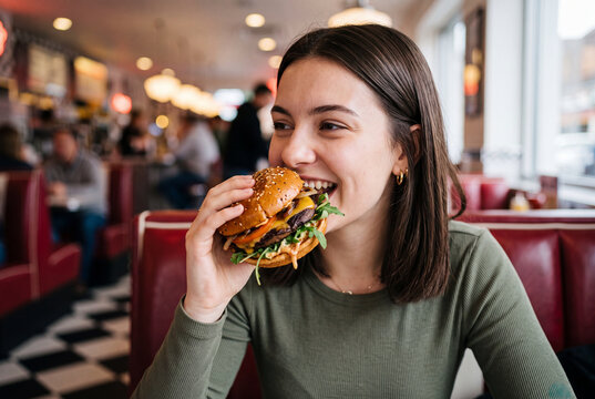 Woman happily eating a big sandwich