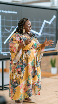 Confident Black woman presenting data insights in a colorful dress during a seminar.