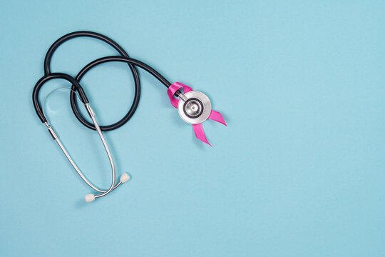 Breast cancer awareness concept with stethoscope and pink ribbon on blue background