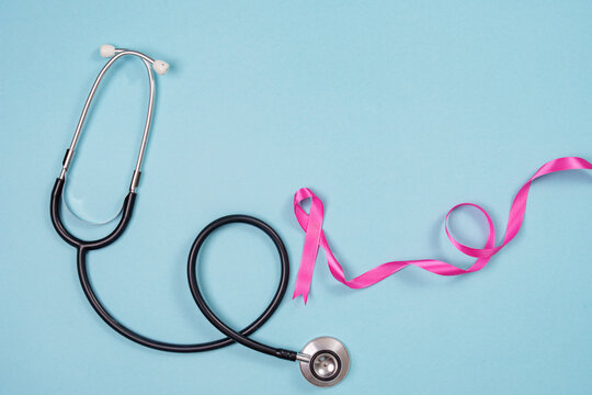 Breast cancer awareness concept with pink ribbon and stethoscope on blue background