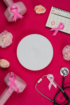 Breast cancer awareness fitness concept with dumbbells stethoscope pink ribbon and blank circle mockup