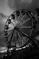 ferris wheel at night with lights and motion and textured cloudy sky black and white © Sandy Ashley
