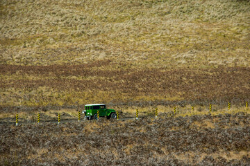 Bright green vintage off-road vehicle driving across the rugged grassy landscape of the Bromo Caldera. Iconic volcanic scenery in East Java, Indonesia. © Max Asrory