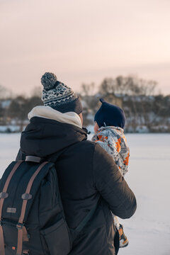 Parent and baby enjoying a winter sunset at Winter time
